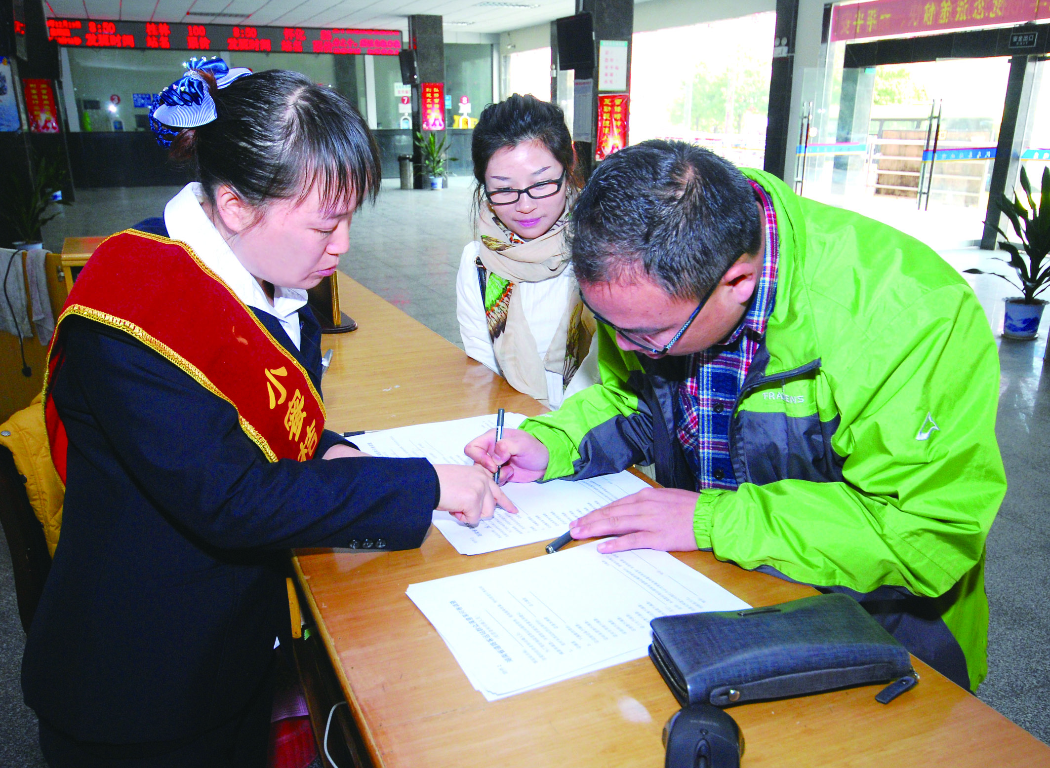 圖為洞口汽車總站站務人員在熱心為旅客服務。